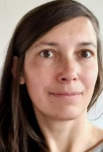 Person mit braunen Haaren lächelt in die Kamera.