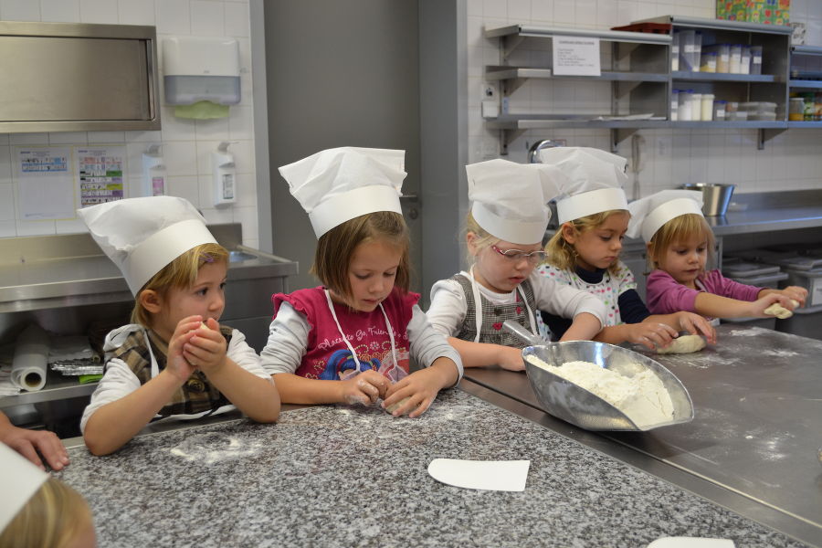 Kindergartenkinder beim Brot backen