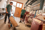 In der Mühle wird von einem Schüler ein Sack Mehl auf einer Sackkarre transportiert.