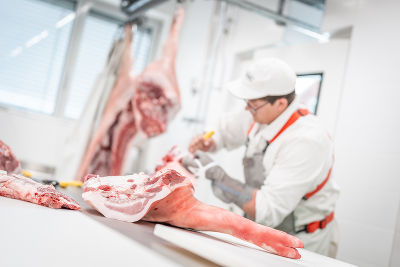Mitarbeiter beim Aufarbeiten von Fleisch