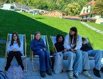 Schüler und Austausschüler in den Liegestühlen vor dem Hofladen