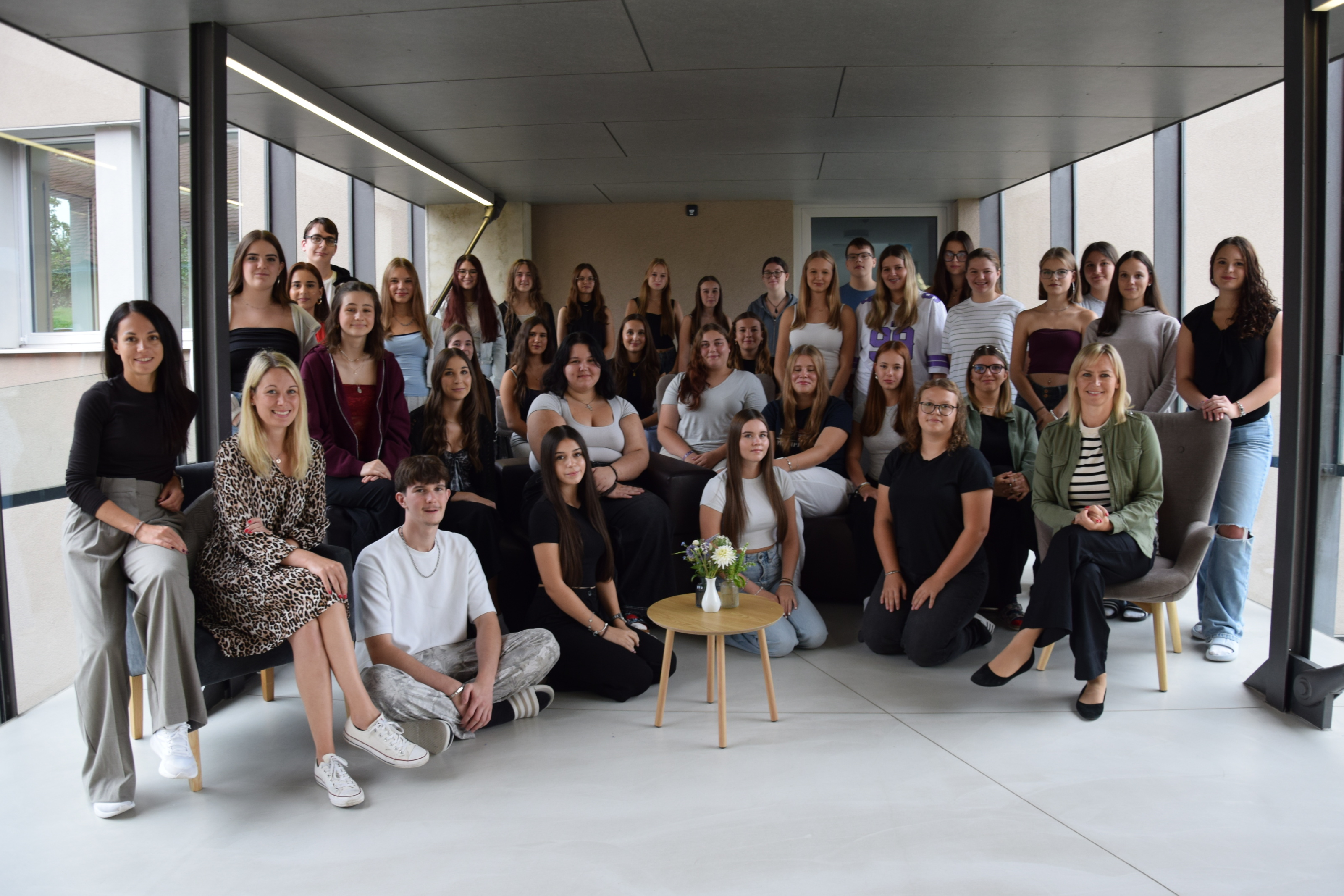 Die SchülerInnen der 3 A Klasse stehen vor dem Schuleingang für ein Gruppenfoto.