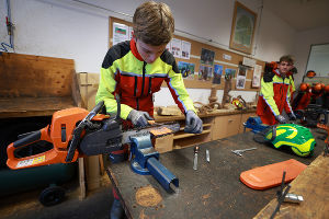 Schüler feilt die Motorsäge 