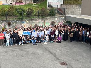 Schüler:innen, Lehrerinnen und Gäste stehen für ein Gruppenbild zusammen
