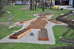 Barrierefreie Gartenanlage mit erhöhten Beeten, um das Wissen um Kräuter für alle zugänglich zu machen.