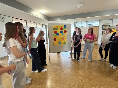 Schülerinnen während einer Präsentation vor einem Flip-Chart