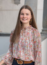 Junge Frau mit langen blonden Haaren und gemusteter Bluse