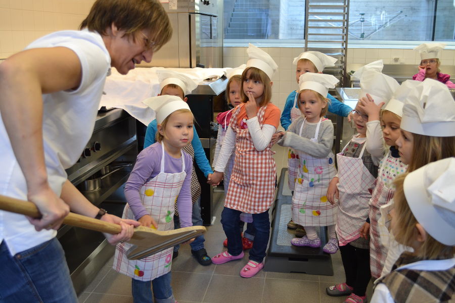 Kindergartenkinder beim Brot backen