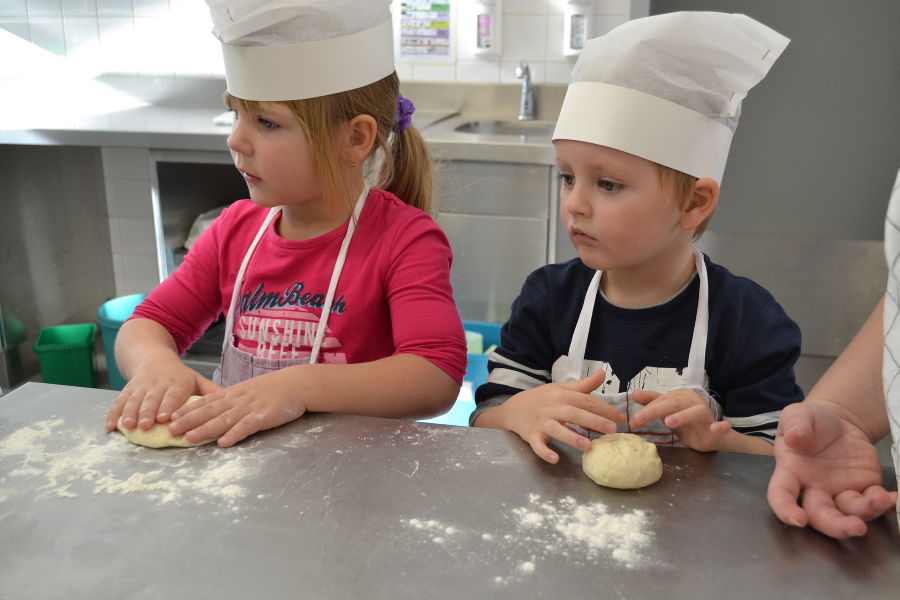 Kindergartenkinder beim Brot backen